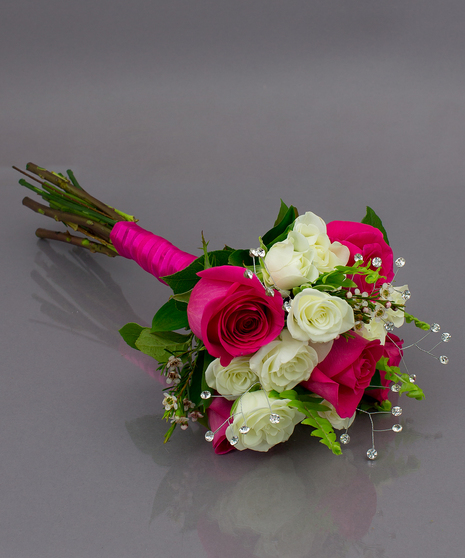 We create these designs by taking beautiful roses and spray roses, hand tying them, and  then finishing them off with a complementing ribbon wrap.