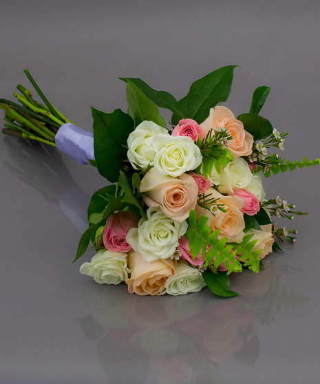 We create these designs by taking beautiful roses and spray roses, hand tying them, and  then finishing them off with a complementing ribbon wrap.