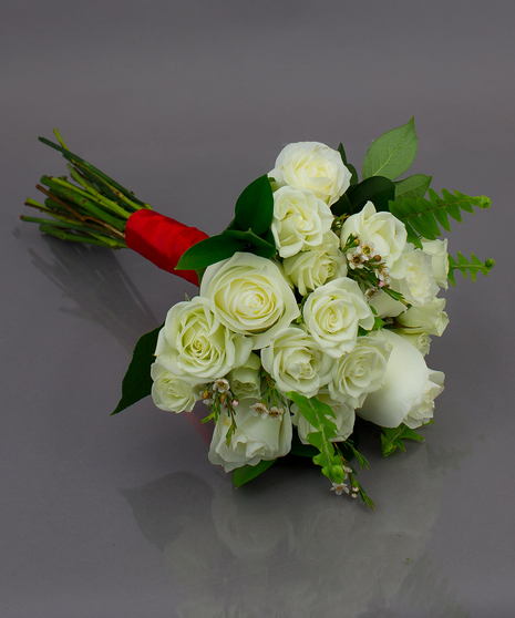 We create these designs by taking beautiful roses and spray roses, hand tying them, and  then finishing them off with a complementing ribbon wrap.