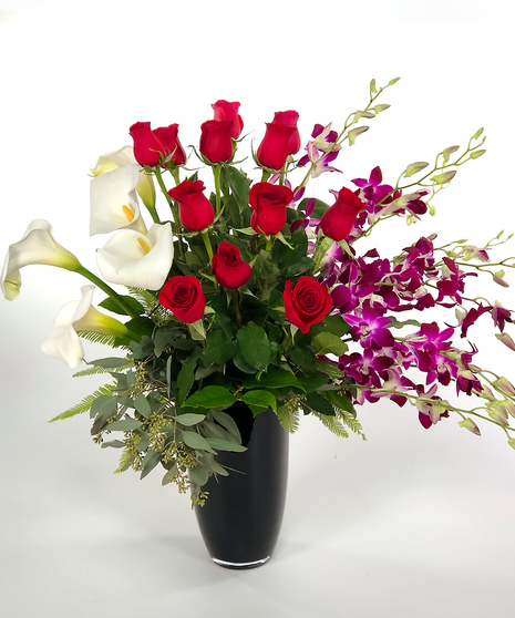 Featuring pristine native grown calla lilies, elegant dendrobium orchids, and farm direct red roses, this design has it all.
