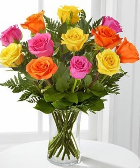 Beautiful hand-picked roses in assorted colors designed in a glass vase with mixed greenery.