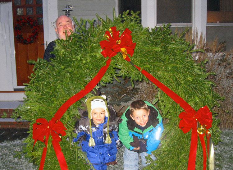 Paul Sr. celebrates Christmas with his grandchildren near an enormous wreath
